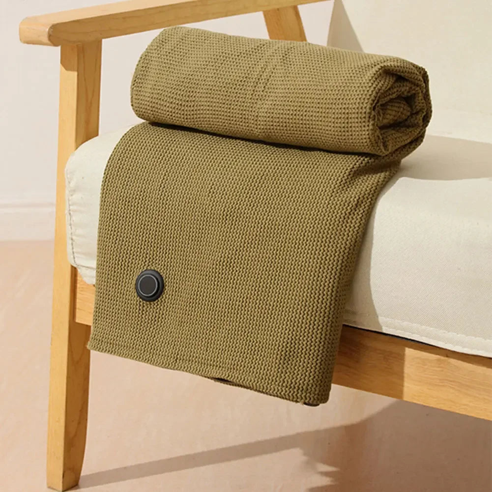 Folded green blanket on a wooden chair with a white cushion