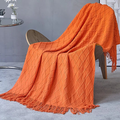 Orange textured blanket draped over a chair in a room setting.
