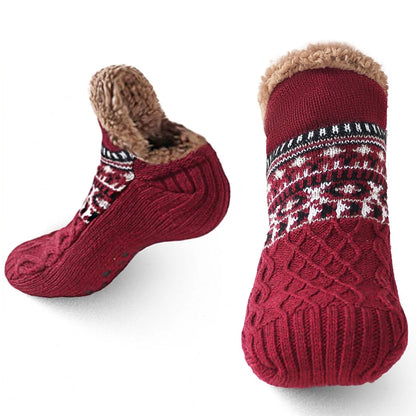 Red knitted socks with patterned sole and brown fur lining on a white background