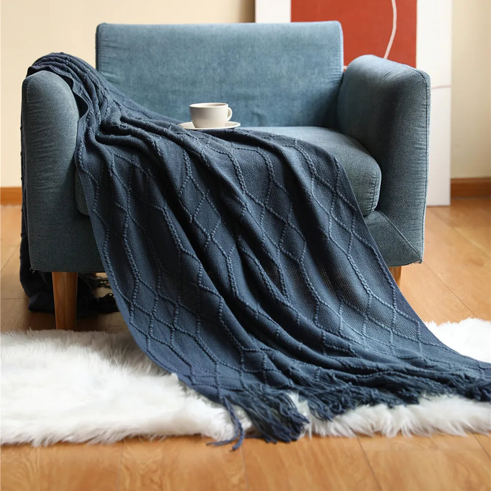 Blue textured throw blanket draped over a blue armchair with a white rug underneath.