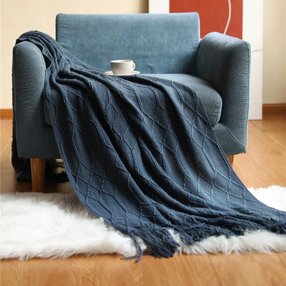 Blue textured throw blanket draped over a blue armchair with a white rug underneath.