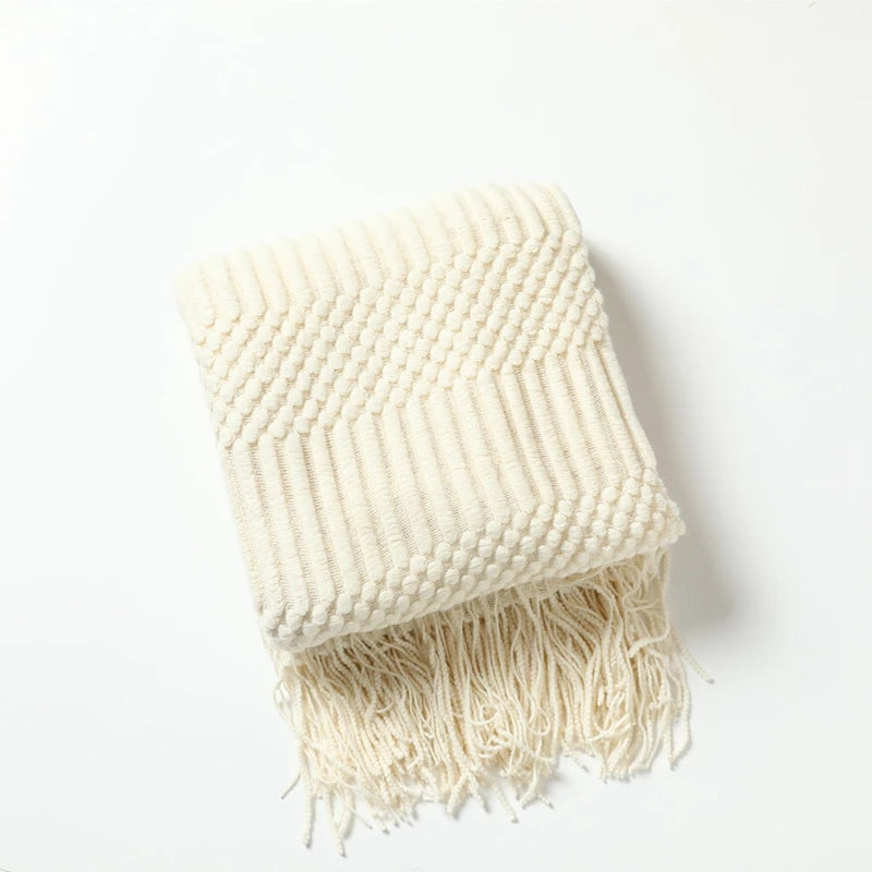 Beige woven blanket with fringe on a white background